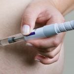 Pessoa aplicando caneta injetável na região abdominal, representando o uso de Mounjaro e os possíveis riscos associados ao medicamento.