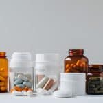 Frascos com diferentes tipos de Medicamentos, como cápsulas e comprimidos, ilustrando o uso controlado e a importância da receita médica para alguns tratamentos.